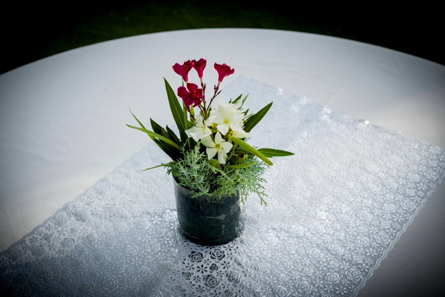 Un petit bouquet posé sur une table dressée en extérieur