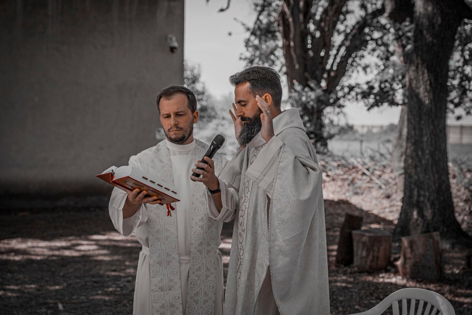 La cérémonie du baptême en plein air, célébrants en aube blanche.