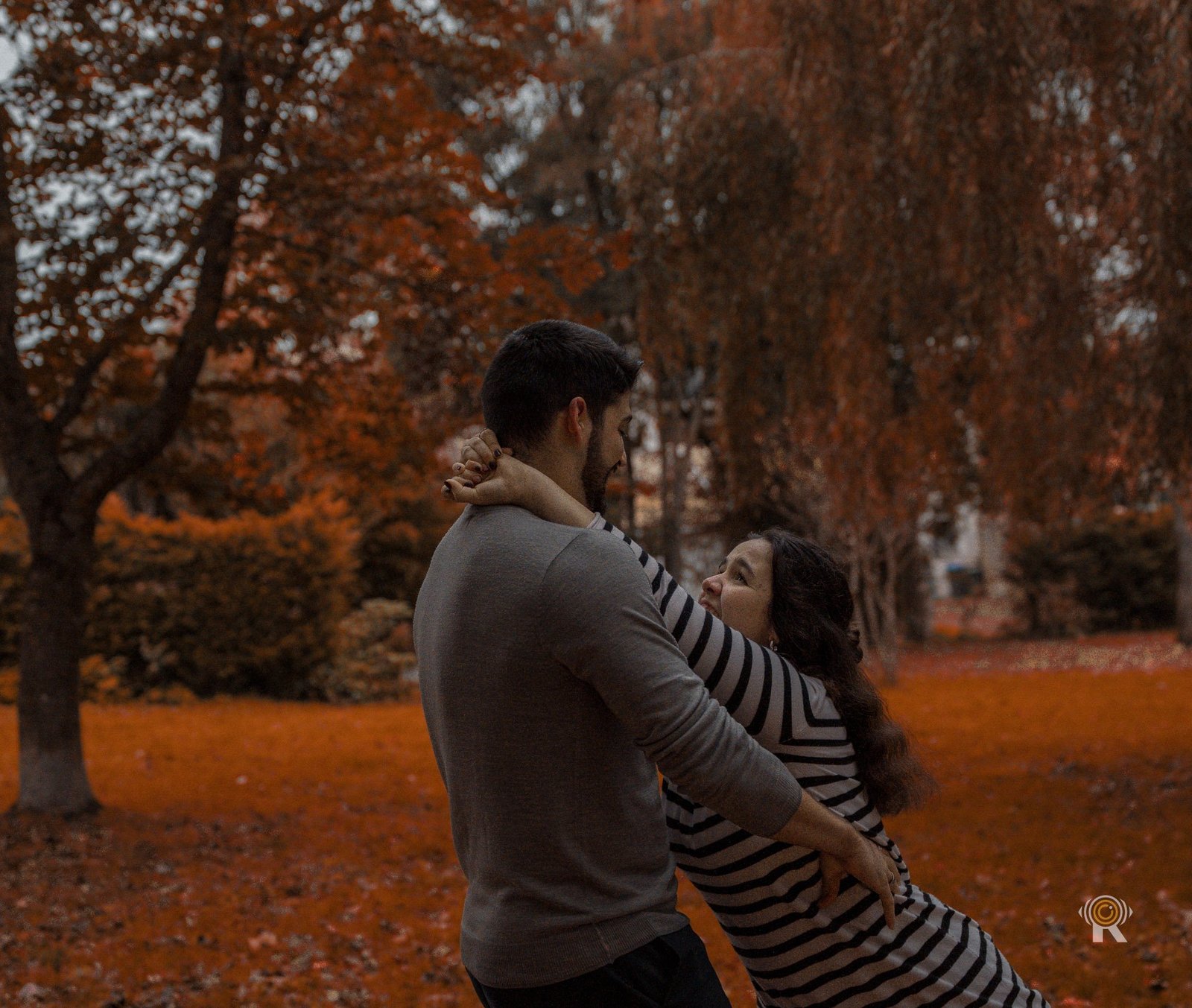 Séance de couple en automne dans un parc, feuilles orange, près de Toulouse.