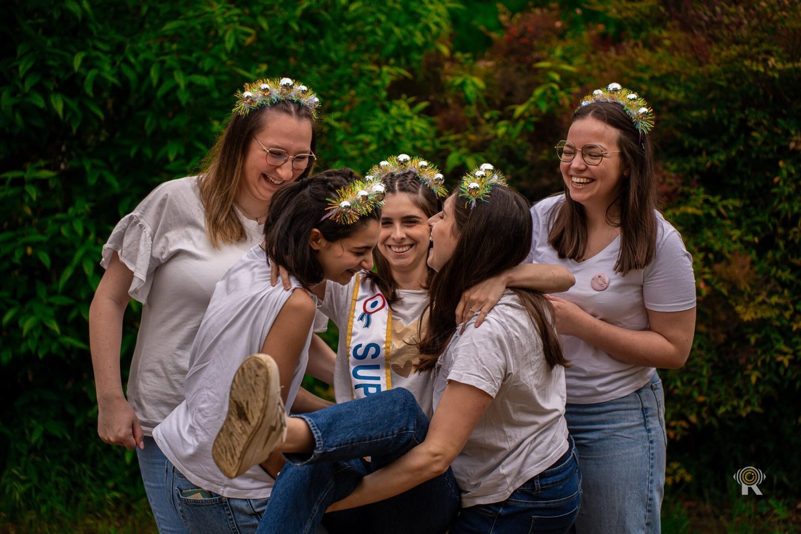 EVJF : les amies aux couronnes de fleurs éclatent de rire ensemble.