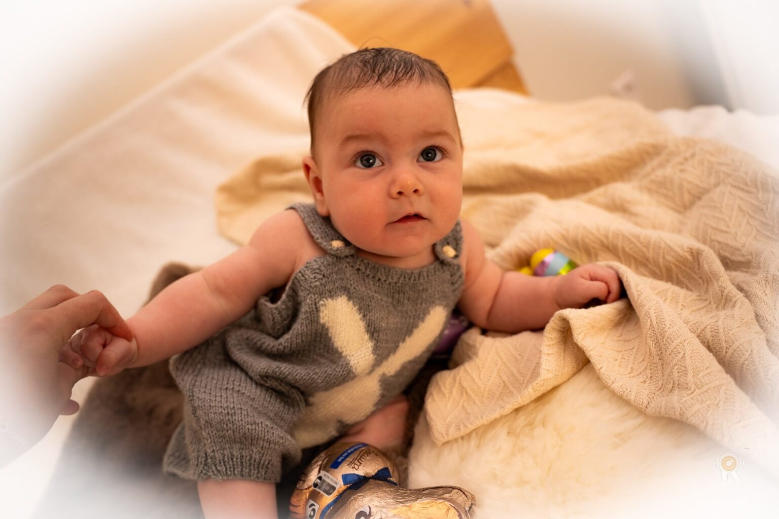 Un bébé assis, qui regarde l'objectif.
