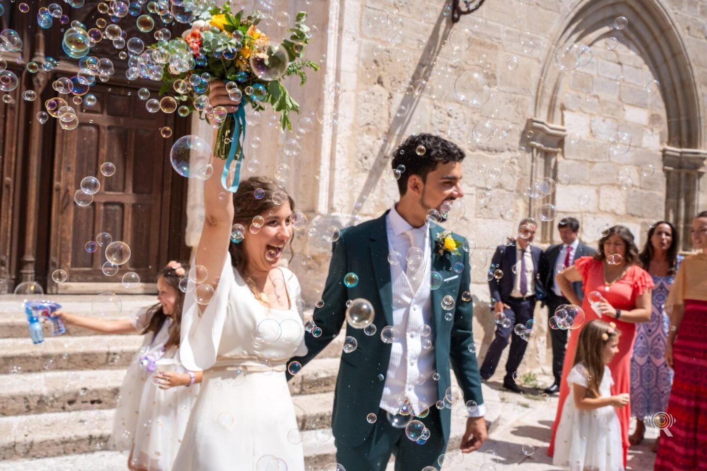 Les mariés à la sortie de l'église, sous une pluie de bulles de savon