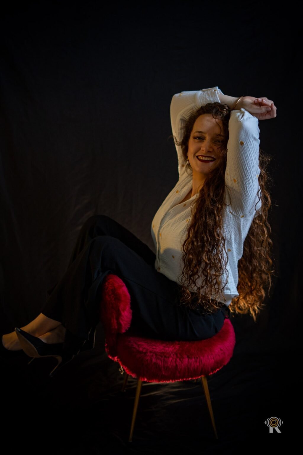 Portrait studio de Jennifer, pose assise, bras levés dans les cheveux
