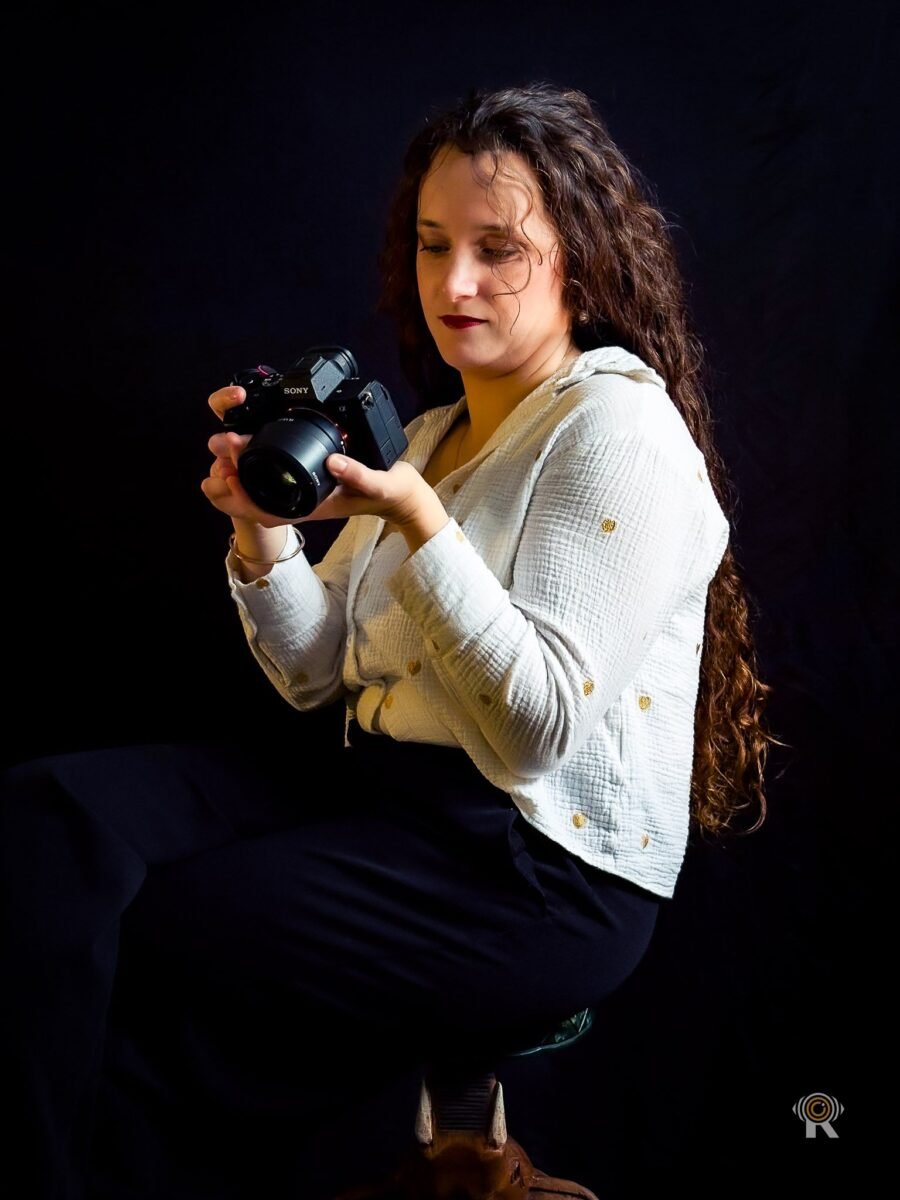 Jennifer Igreja baisse les yeux sur un boîtier Sony tenu à deux mains, sur un tabouret