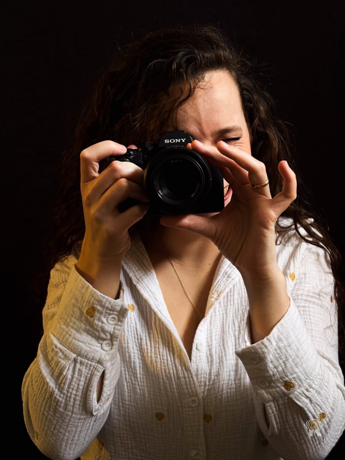 Jennifer photographiant avec un appareil Sony, en studio