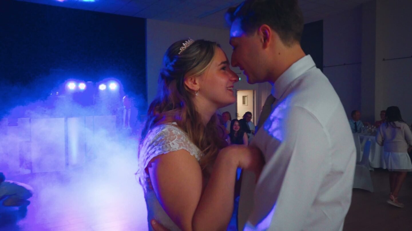 Premier bal des mariés, dans la fumée et la lumière bleue de la salle.