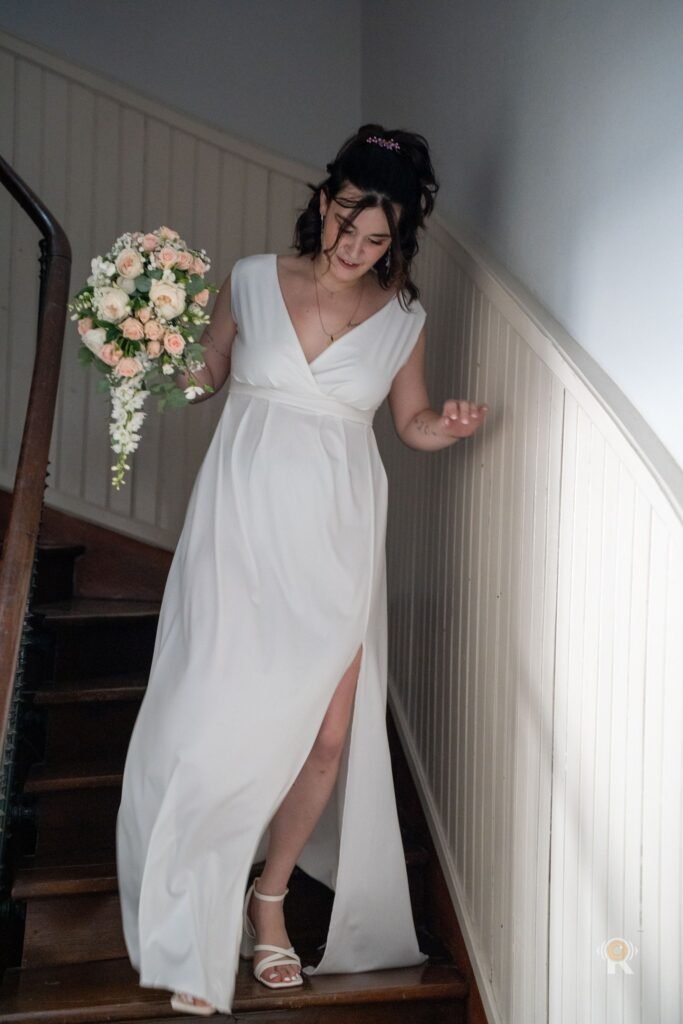 Jessica descend l'escalier, son bouquet à la main