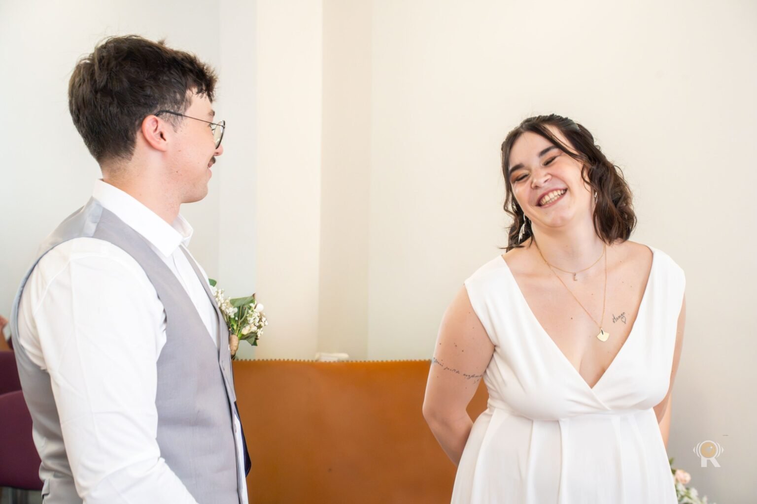 Les mariés qui se sourient, à l'entrée de la salle de cérémonie.