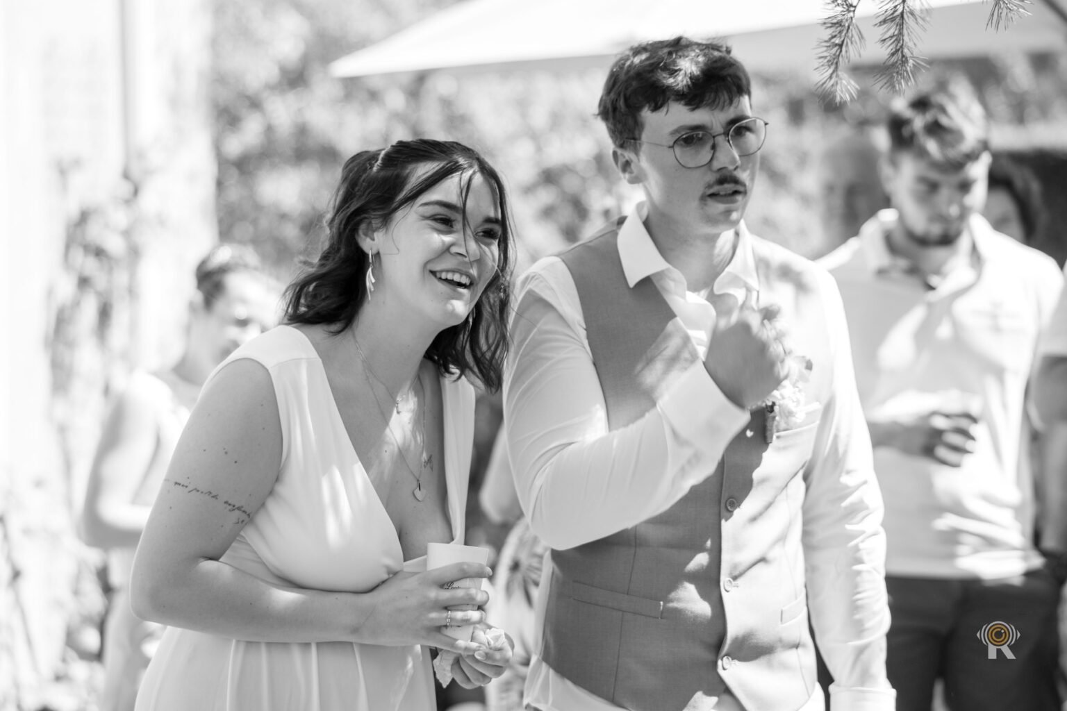 Les mariés rient ensemble, un verre à la main, photo en noir et blanc