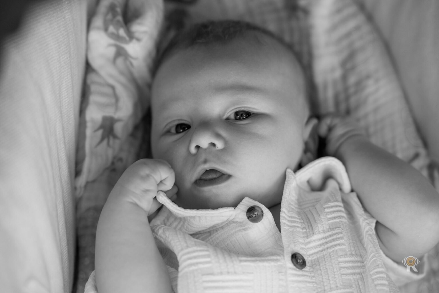 En noir et blanc, un bébé dans son lit, à la maison