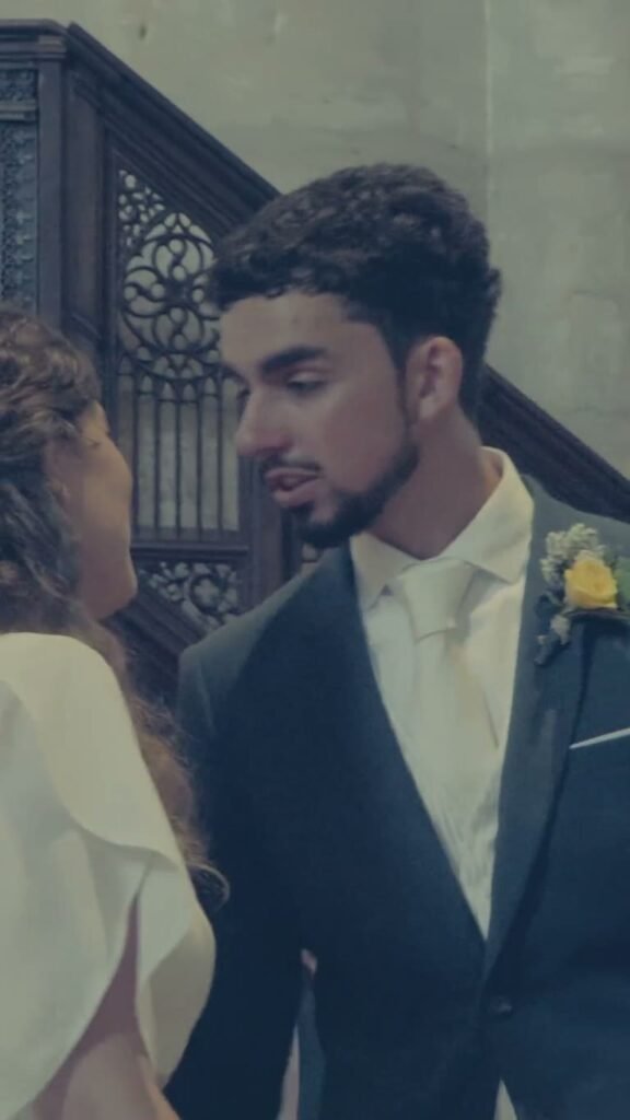 Le marié, boutonnière jaune à la veste, près de la mariée.