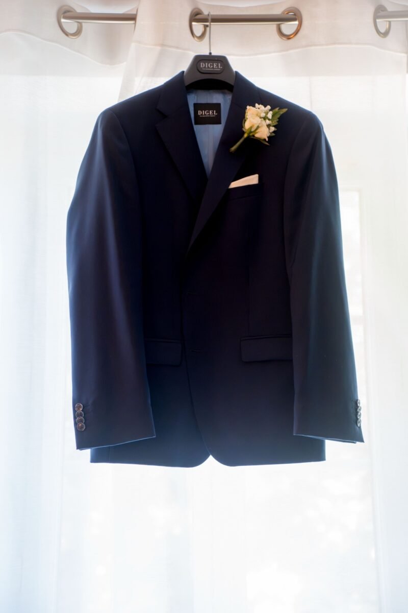 Une veste suspendue à contre-jour, avec une fleur.