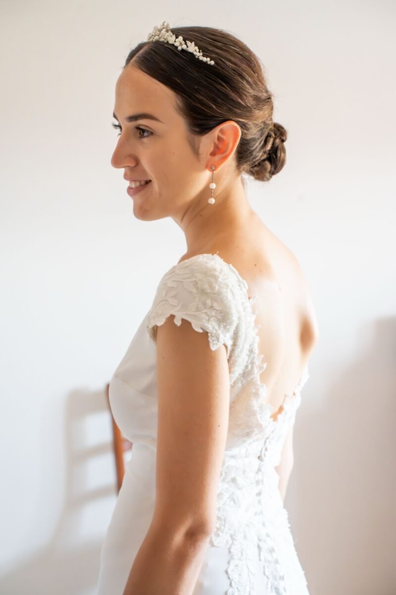 La mariée de profil, coiffée d’un diadème, avec un sourire calme.