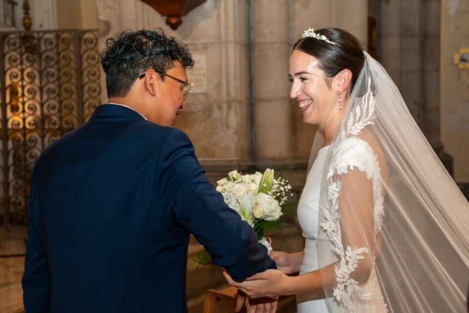 Le marié lui prend la main et la mariée rit.