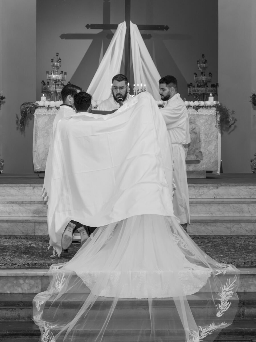 Rite du voile en noir et blanc, le couple sous le tissu, la traîne étalée.