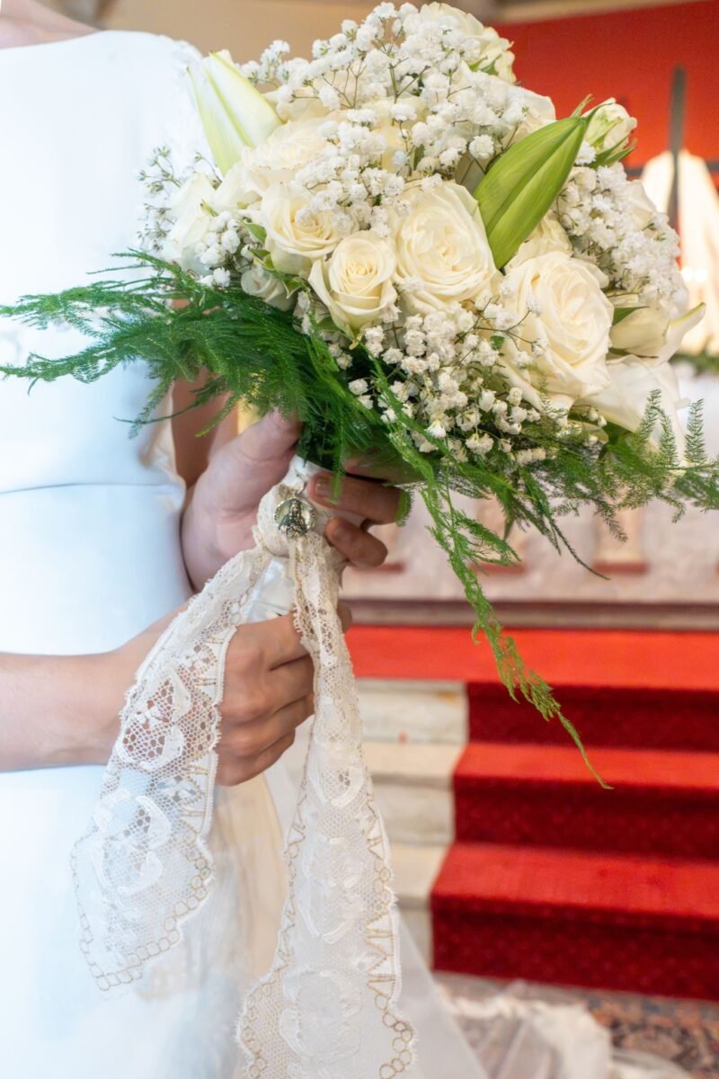 Le bouquet et sa dentelle posés sur les marches rouges de l’autel.