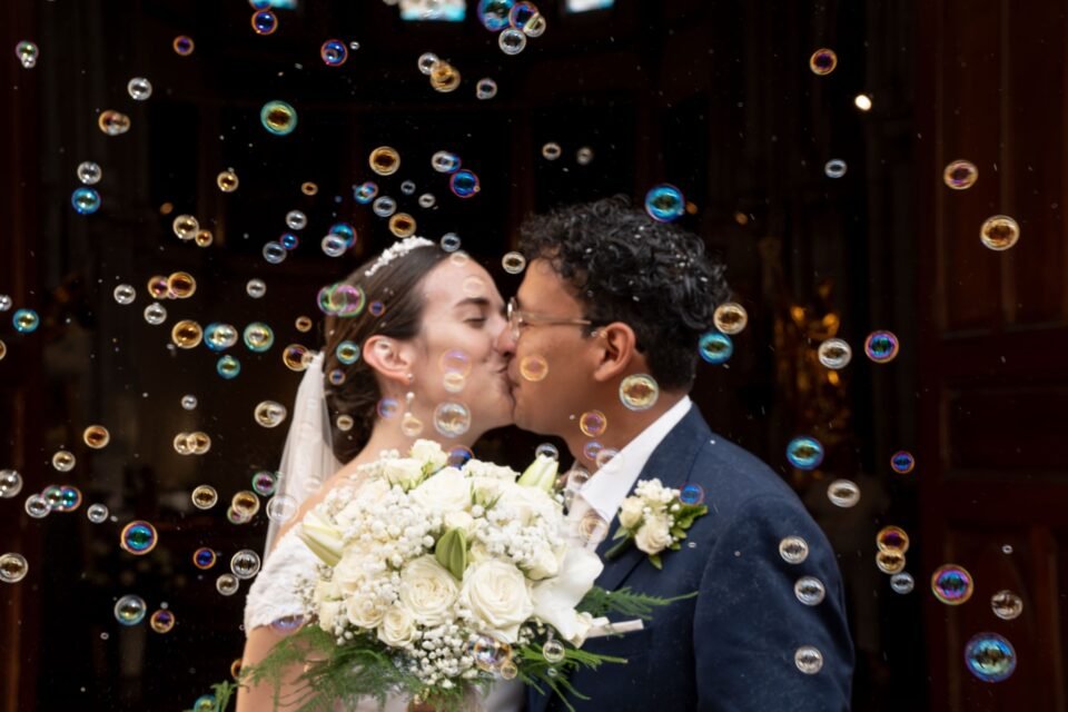 Baiser au milieu des bulles de savon, devant une porte sombre.