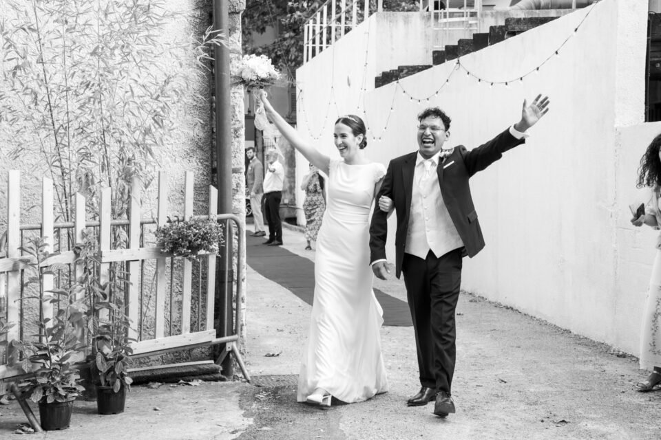 En noir et blanc, ils entrent dans le vin d’honneur, les bras en l’air.